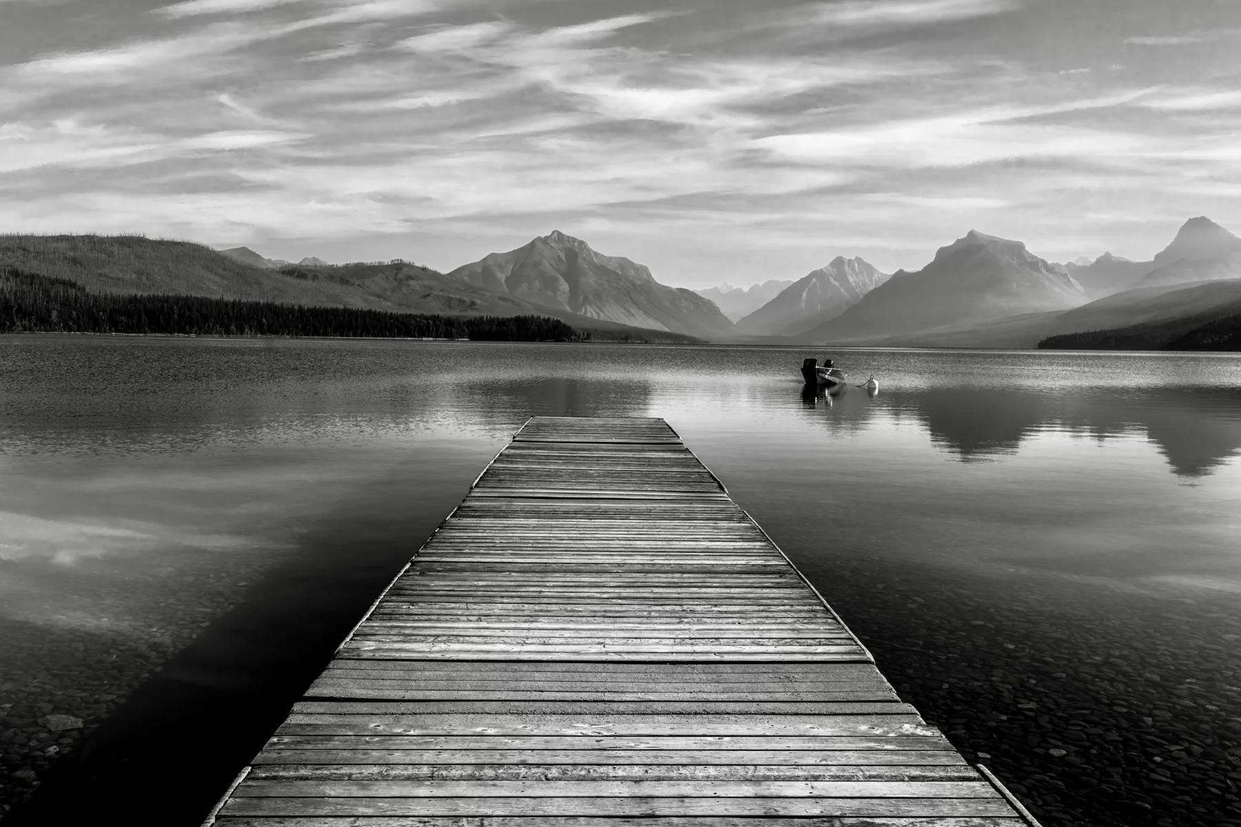 A peaceful Montana lake beneath forested mountain peaks
